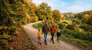 A professional, high-angle editorial photograph of a happy family walking along a winding, sun-drenc