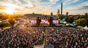A professional, high-angle editorial shot of a vibrant outdoor music festival stage in the Silesian