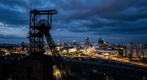 A professional editorial photograph capturing the contrasting silhouette of a historic brick coal mi